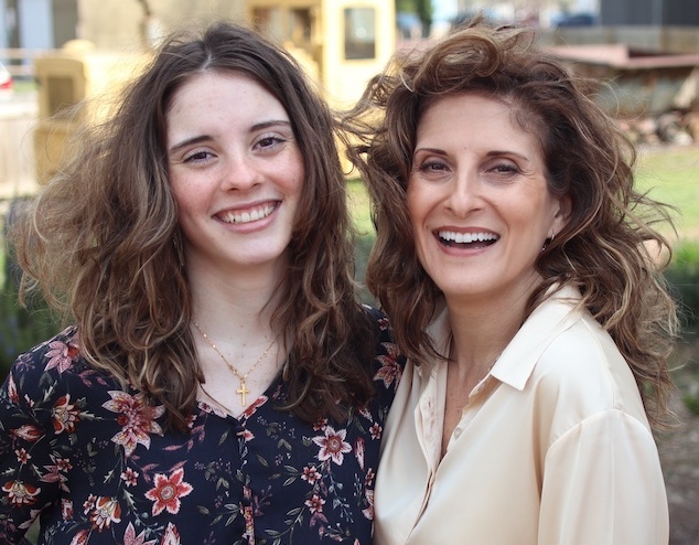 Elena Patrice smiling with her daughter outdoors.