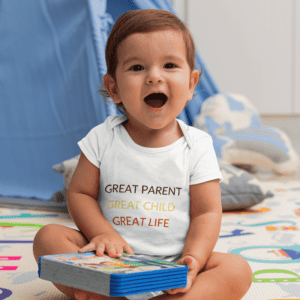 Toddler in a "Great Parent Great Child Great Life" shirt holding books.